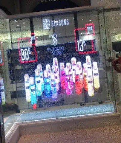 Vitrina con LED Film que muestra frascos de perfume de colores frente a una tienda